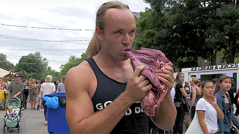 un hombre consume carne cruda en un festival vegano
